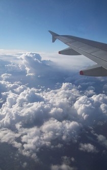 Wolken unter dem Tragflügel eines Flugzeuges.